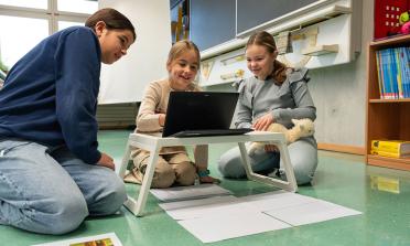Drei Schülerinnen arbeiten am Laptop an ihrem Film